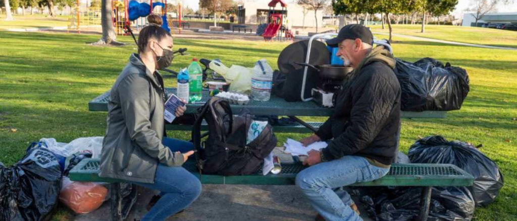 Lauren Justice, a Lead Caseworker for Anaheim’s Community Care Response Team (CCRT), talks with Tony Potts in Juarez Park in Anaheim, CA on Thursday, February 25, 2021. Potts, who is homeless along with his twin brother, has been on the streets for eight years. CCRT connects the homeless with services and shelter. (Photo by Paul Bersebach, Orange County Register/SCNG)